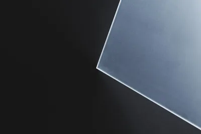 Dunne matte glasplaat met scherpe rand op donkere achtergrond, minimalistisch en modern ontwerp