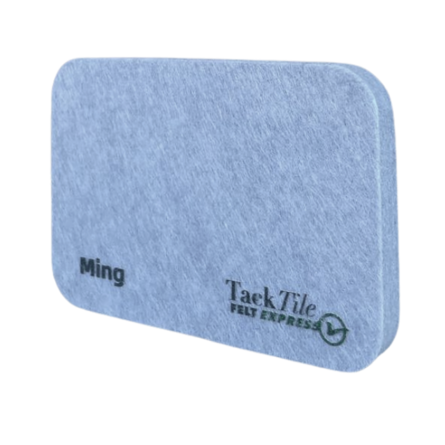Grijze vilt tegel met afgeronde hoeken, voorzien van de tekst "Ming" en het logo van TaekTile.