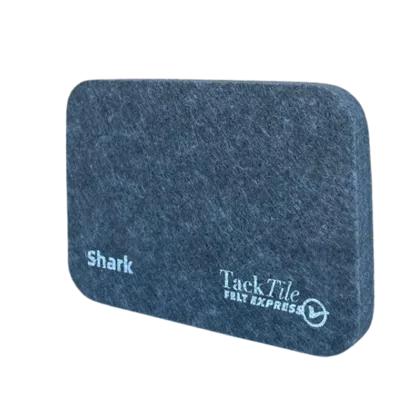 Grijze, rechthoekige Shark Tack Tile met afgeronde hoeken en een logo op de voorkant.